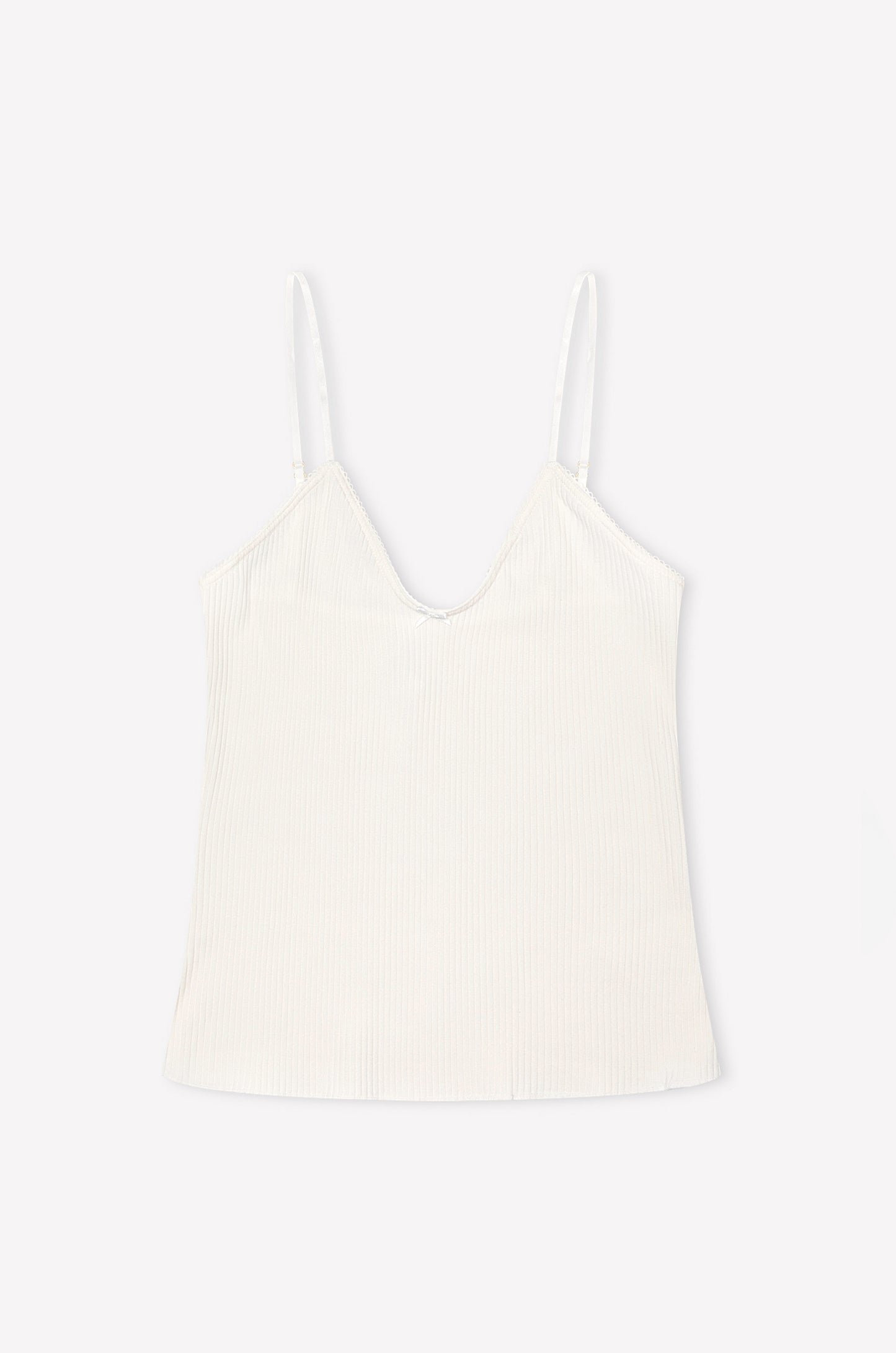 The Margot Tank in pumice by 0 features a white ribbed jersey fabric, V-neckline, and thin adjustable straps, shown laid flat on a light background.
