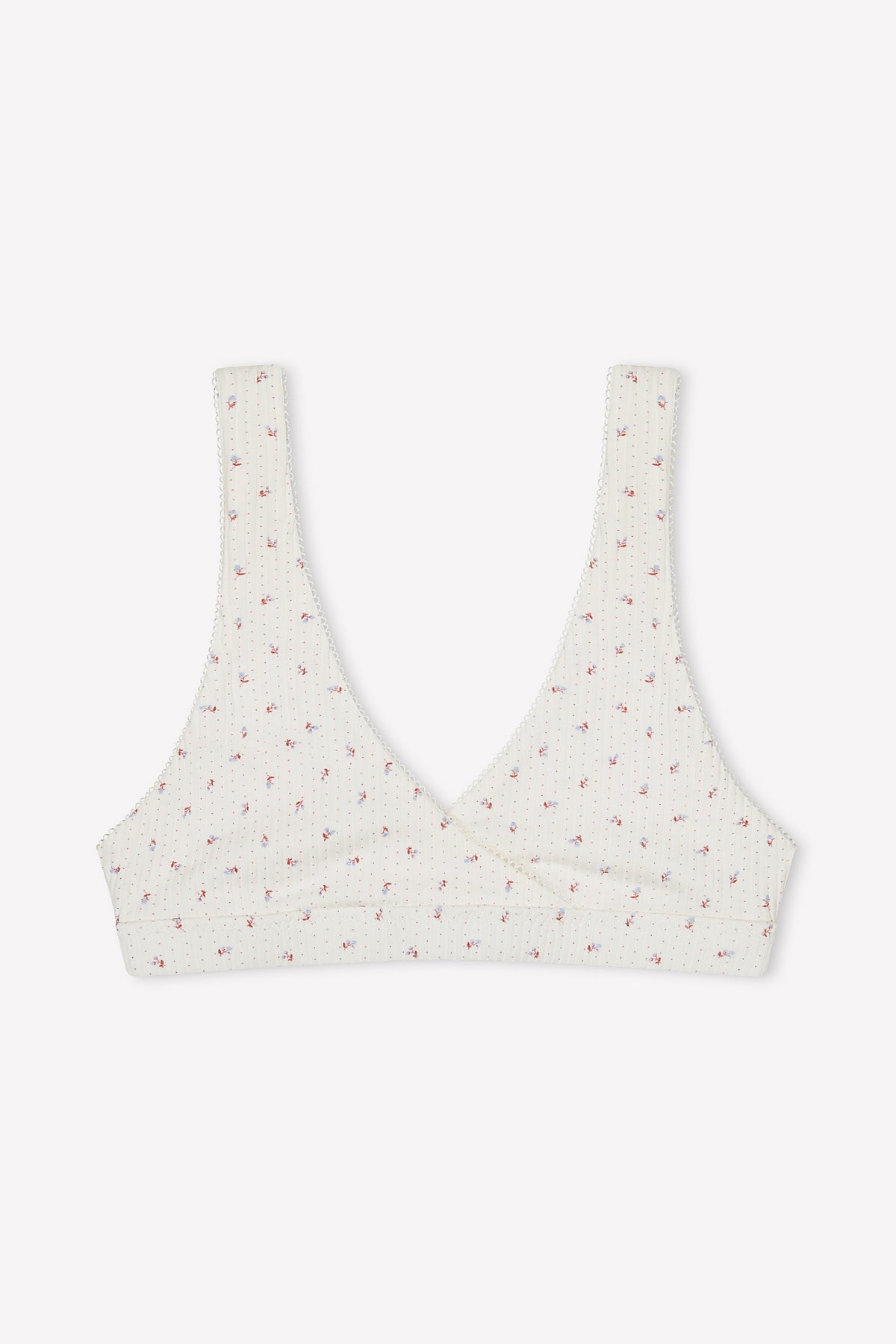 The Bernie Bra - Flora is a cream-colored, ribbed cotton triangle bra featuring a subtle pink floral pattern and supportive underbust wrap-style front, shown on a plain white background.