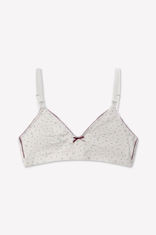 Introducing the Paloma Maternity Bra - Blue Floral: a blue, delicately patterned soft-cup maternity bra crafted from organic cotton. It features adjustable straps, elegant maroon stitching along the edges, and a small maroon bow at the center front. Convenient nursing clips make breastfeeding easier for new mothers. Shown against a simple, light background. Brand: 0.