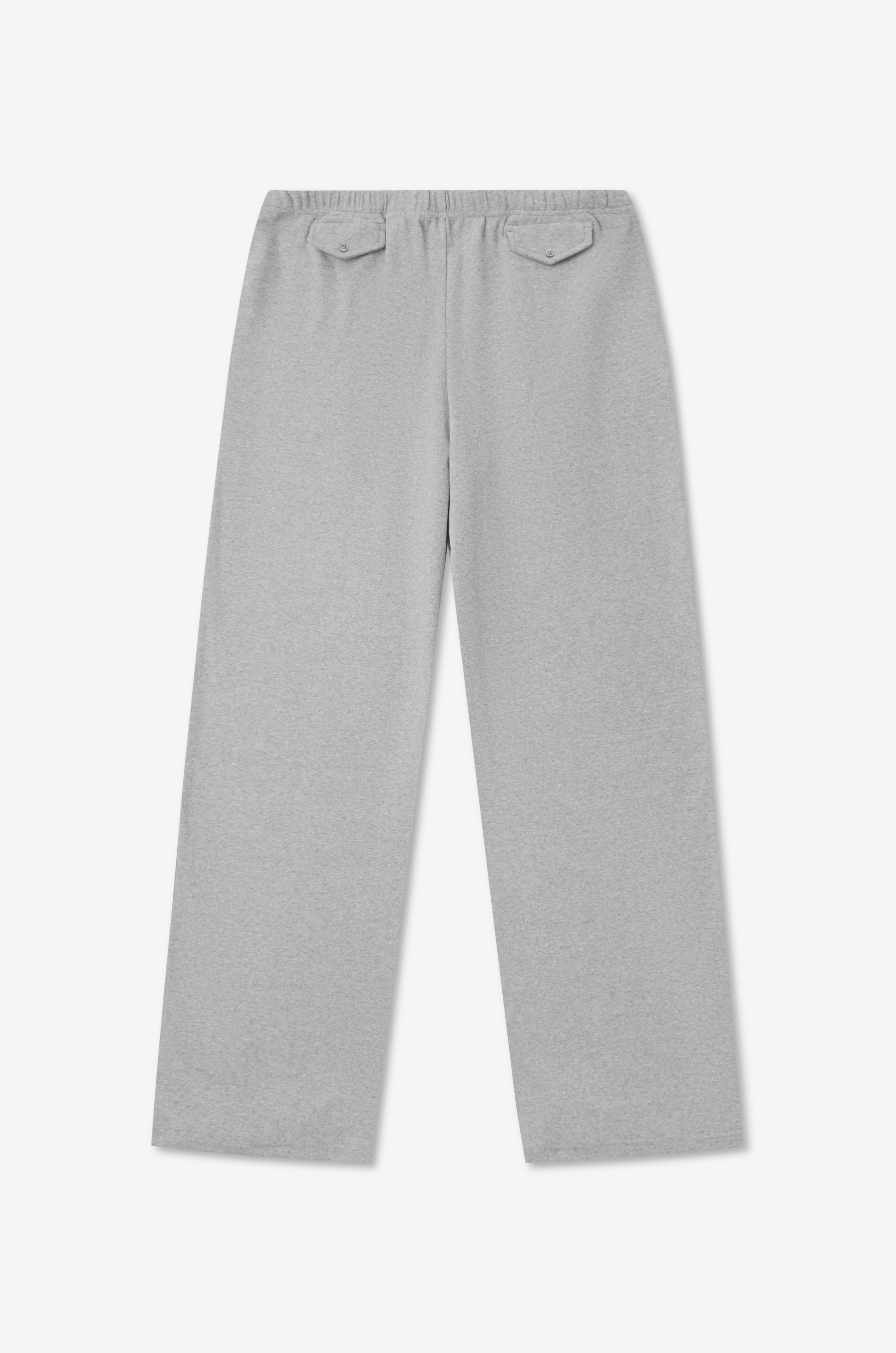 The Vera Track Pant - Grey by 0 features a light gray hue, relaxed fit with wide legs, and an elasticated waistband. The design includes two back pockets with buttoned flaps, showcased against a white background.