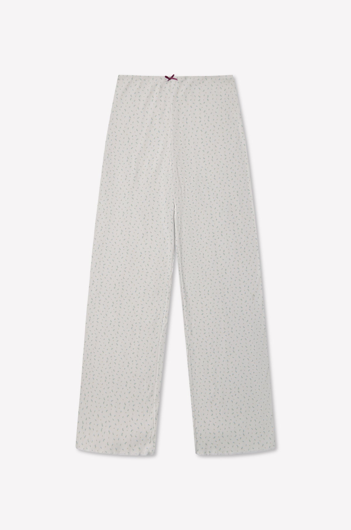 The Maya Pant - Blue Floral by 0 is crafted from organic cotton, featuring a comfortable waistband and finished with a small red bow at the top. These pants are laid flat on a plain background, showcasing their subtle blue floral pattern.