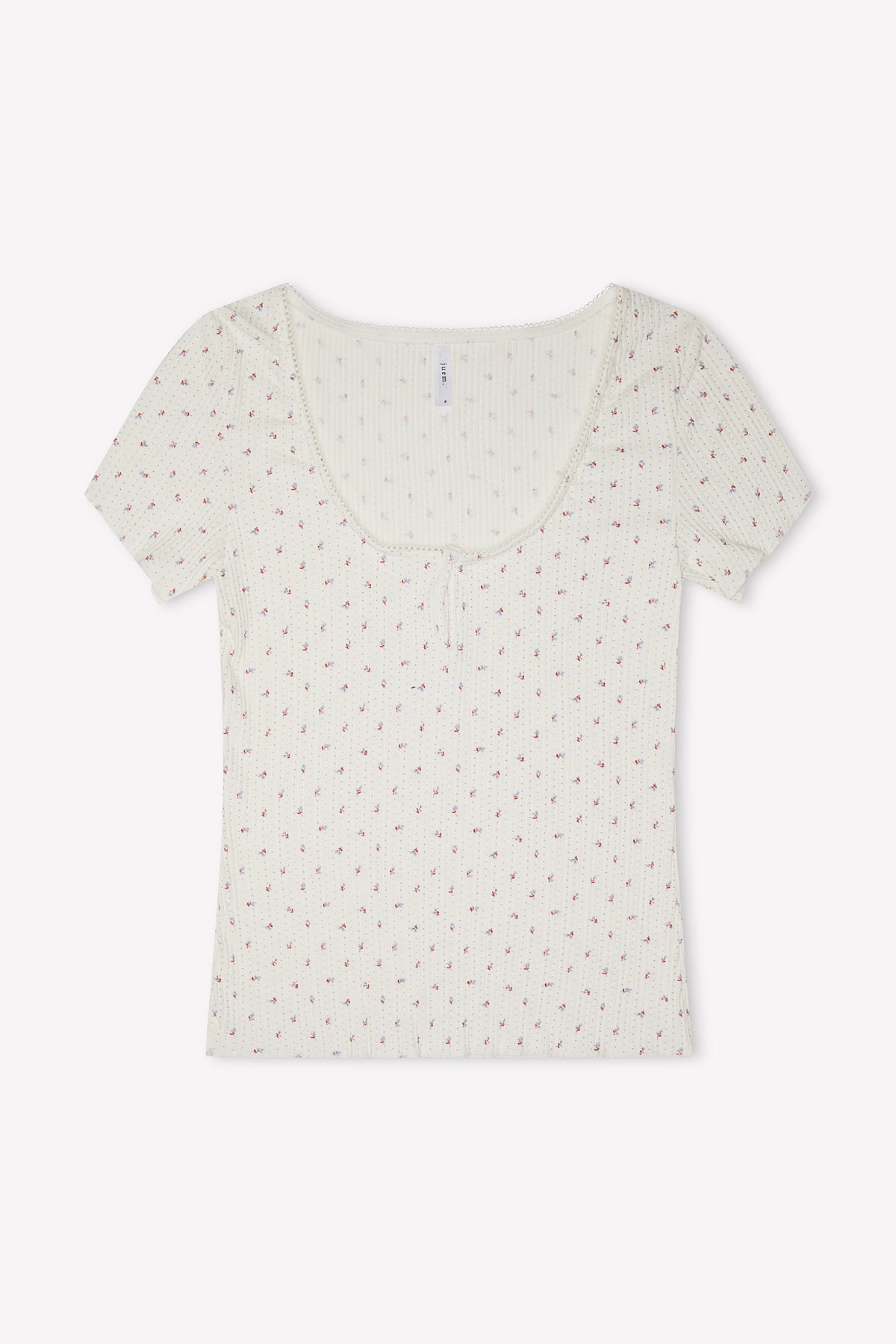 The Effie Tee - Flora is a short-sleeve, scoop-neck white ribbed elastane top featuring a subtle pink floral pattern and a small bow at the neckline, shown laid flat on a white background.