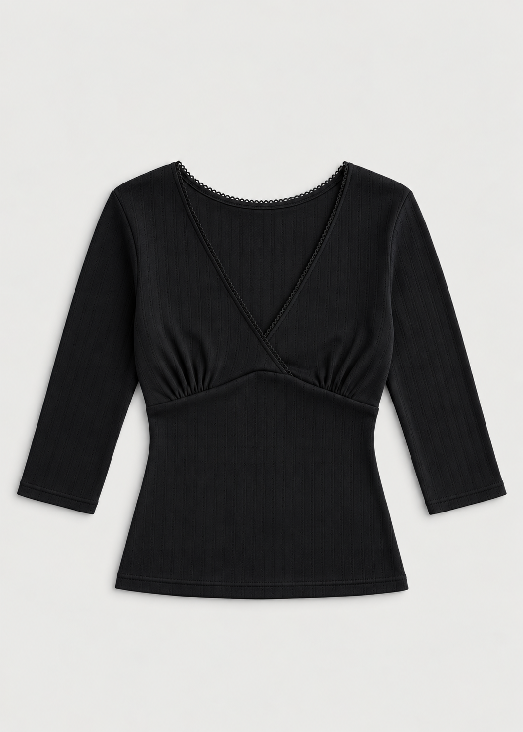 The Fern Top - Black by Juem laid flat on a pale background, a soft pointelle knit top with a v-neck crossover front, gathered bust panel and 3/4 sleeves.
