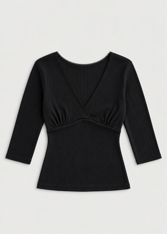 The Fern Top - Black by Juem laid flat on a pale background, a soft pointelle knit top with a v-neck crossover front, gathered bust panel and 3/4 sleeves.