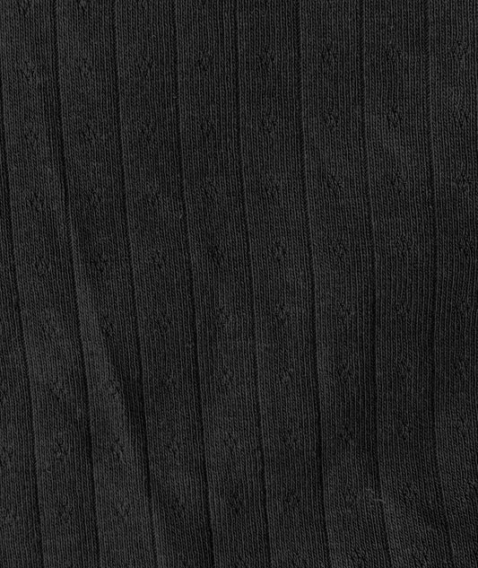 A close-up of the Fern Top - Black by Juem, showing the black pointelle knit with its fine openwork detail.