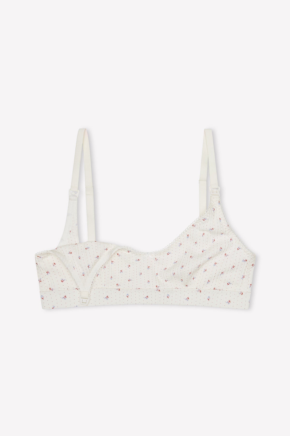 The Jane Maternity Crop - Flora is a white scoop neck bralette with thin adjustable straps, ribbed texture, and pink floral print. Made from organic cotton, it offers a seamless design and front clasp for comfort.