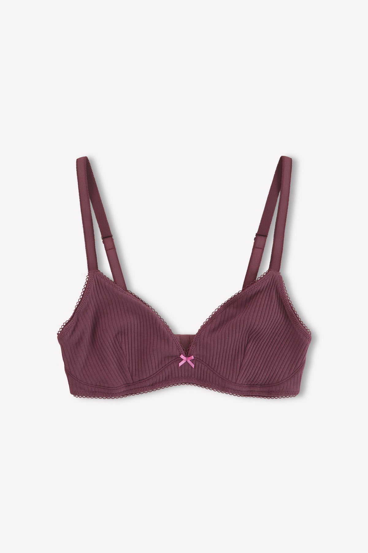The Sophia Soft Tri - Plum by 0 is a maroon everyday bra with thin straps, ribbed fabric, lace trim, and a pink bow at the center. It offers medium coverage and is shown laid flat on a white background.