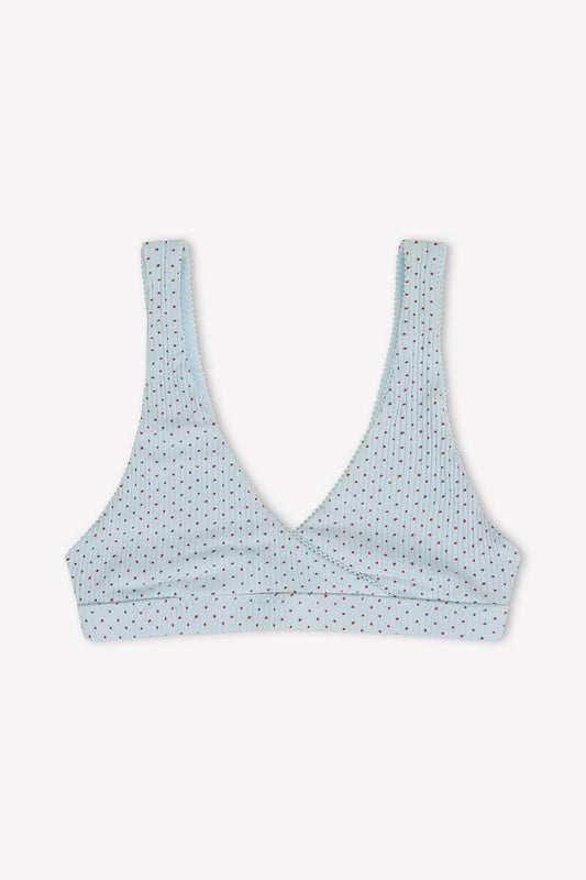 The Bernie Bra - Polka by 0 is a light blue, unpadded triangle bra with a deep V-neckline, thin straps, and features subtle rows of multicolored polka dots for simple style.