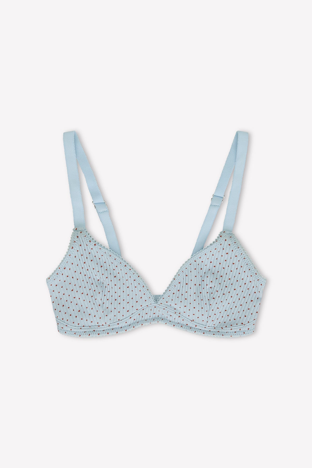 The Sophia Soft Tri - Polka by 0 is a light blue organic cotton triangle bra with small red polka dots, vertical stitching, and adjustable shoulder straps. Set against a plain white background.
