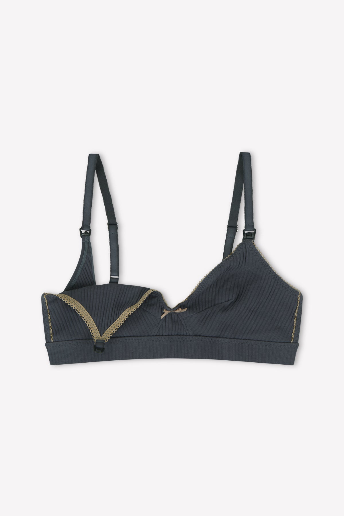 The Paloma Maternity Bra - Moon by 0 features dark gray ribbed fabric, adjustable straps, gold lace trim on one cup, a central bow, and discreet nursing clips for easy breastfeeding. One cup is shown partially pulled down.