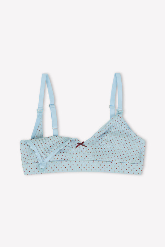 The Paloma Maternity Bra - Polka by 0 features a light blue polka-dot design, adjustable straps, nursing clips, a small front bow, and is shown with one cup unclipped to display the interior.