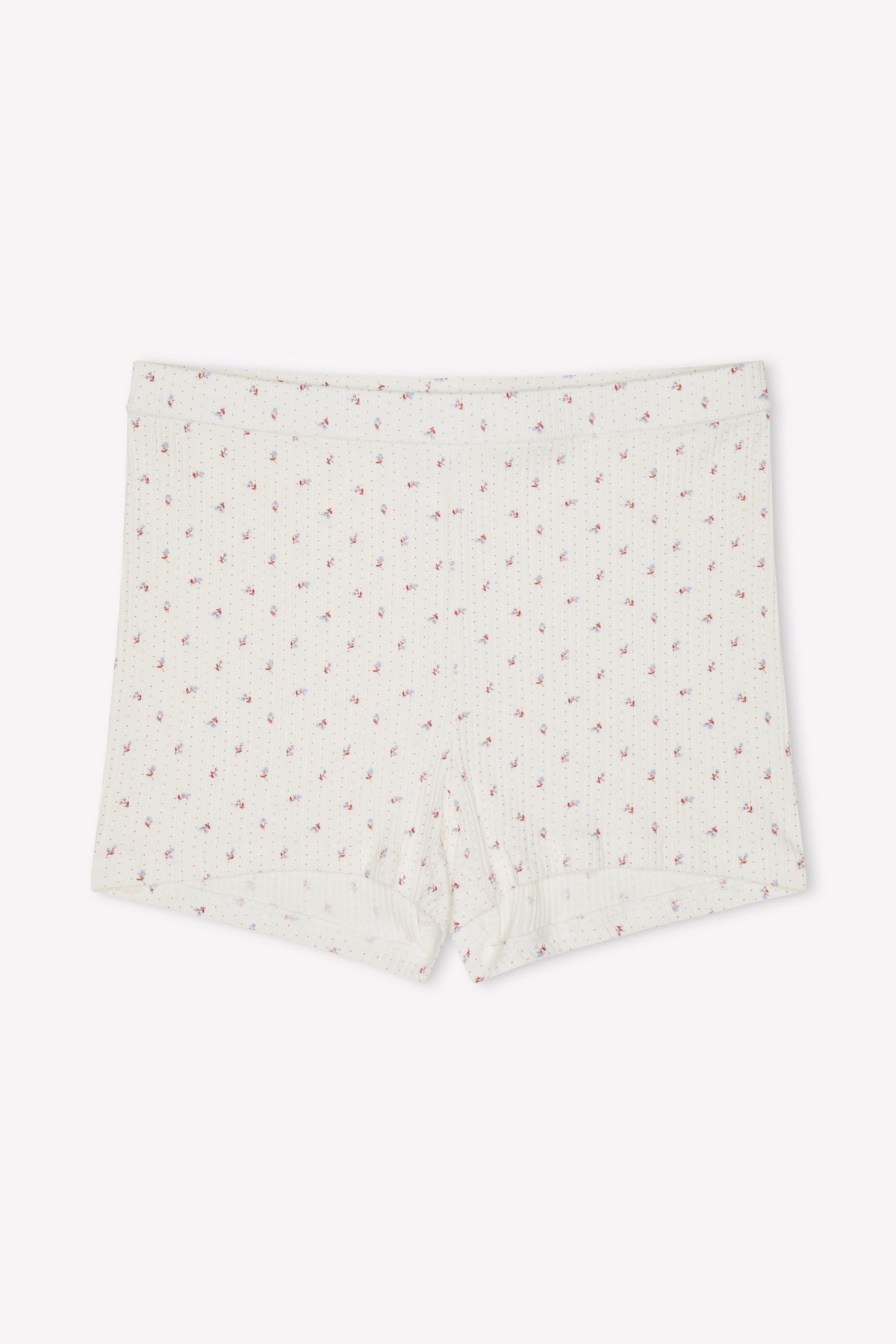 The Maggie Short - Flora is an off-white, organic cotton short featuring a ribbed, mid-rise fitted style and a subtle pink floral print, shown against a plain white background.