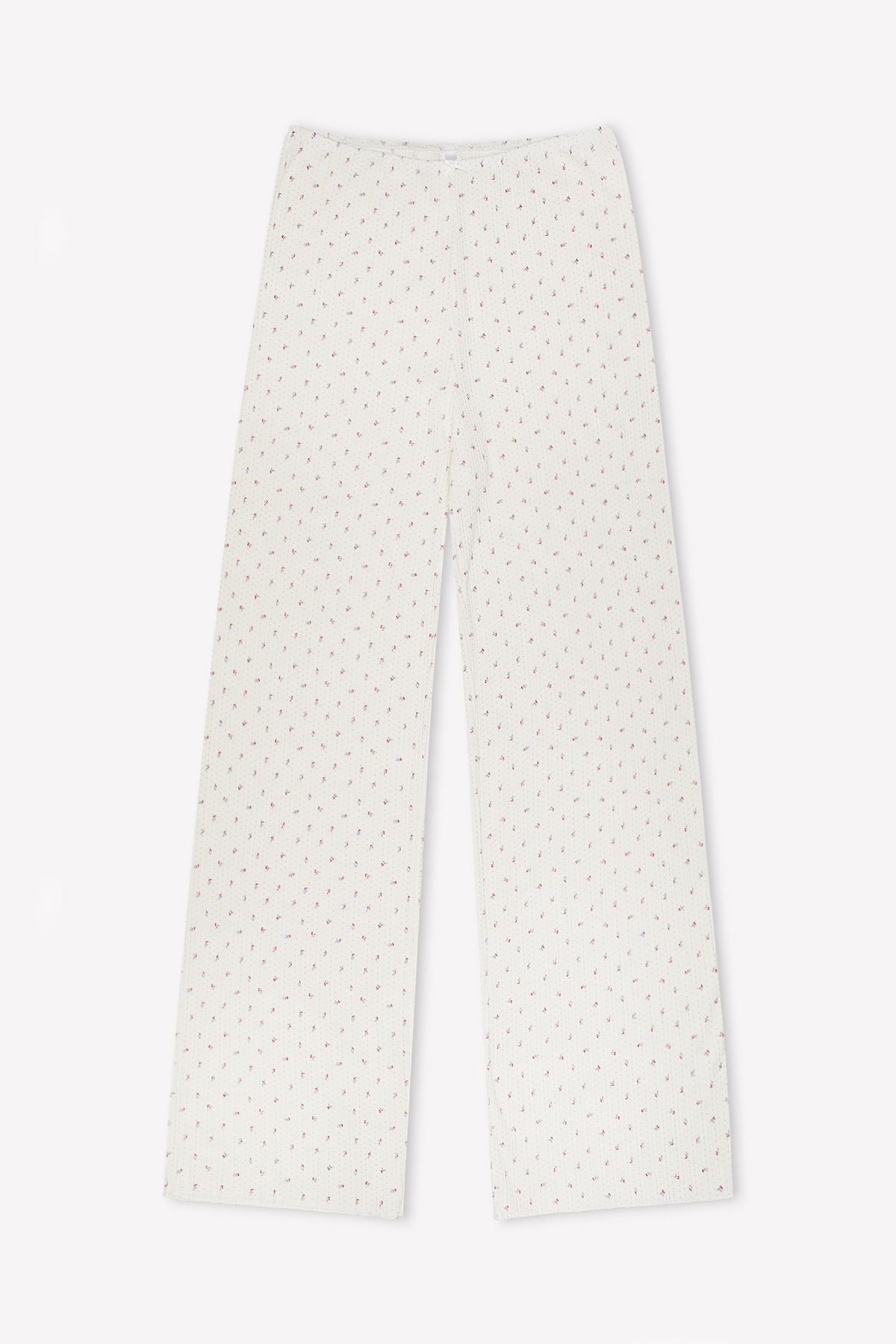 The Maya Pant - Flora features wide-leg white pajama pants with a small red dotted pattern, made from organic cotton for comfort, shown laid flat on a white background.