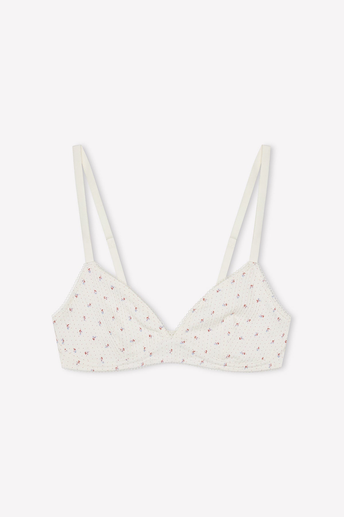The Sophia Soft Tri - Flora is a white organic cotton triangle bra with thin adjustable straps, delicate pink floral print, and lightly gathered texture. The soft cup style is shown laid flat on a plain white background.