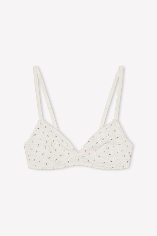 The Sophia Soft Tri - Flora is a white organic cotton triangle bra with thin adjustable straps, delicate pink floral print, and lightly gathered texture. The soft cup style is shown laid flat on a plain white background.