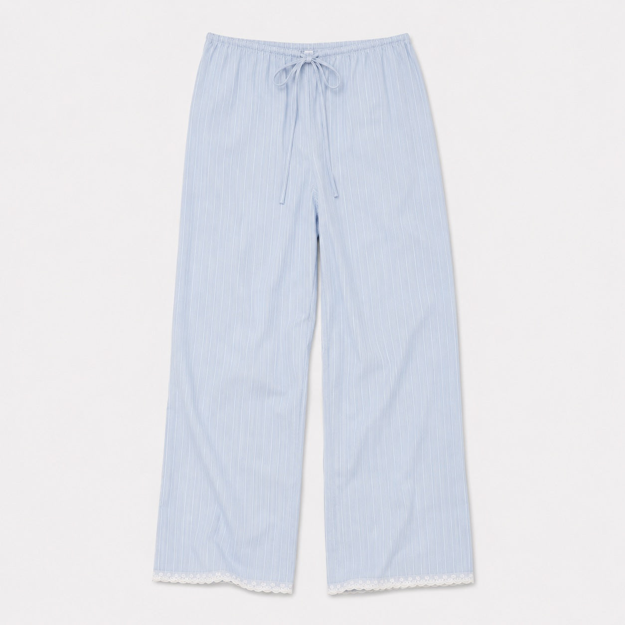The Josephine Pant - Cloud Stripe by 0 features light blue organic cotton with thin white stripes, an elastic drawstring waist, relaxed straight leg, and white lace-trimmed hem, shown laid flat on a white background.